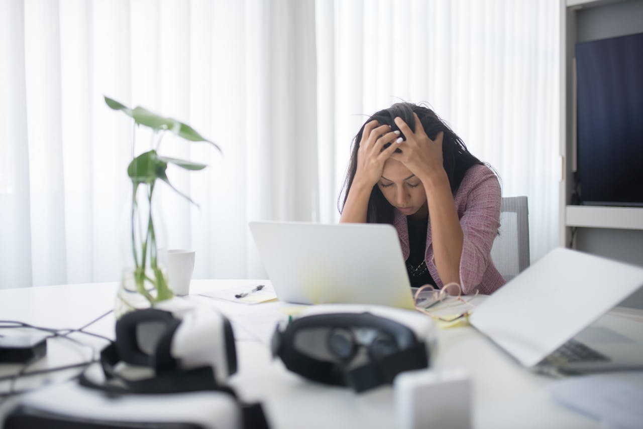 The Art of Drawing Readers In: Your attractive post title goes here Frustrated woman sitting at desk with laptop, showing stress in a modern office environment.